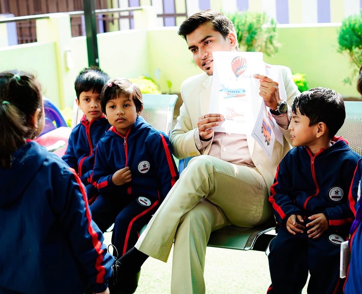 Centre Head showing picture cards to a group of attentive children