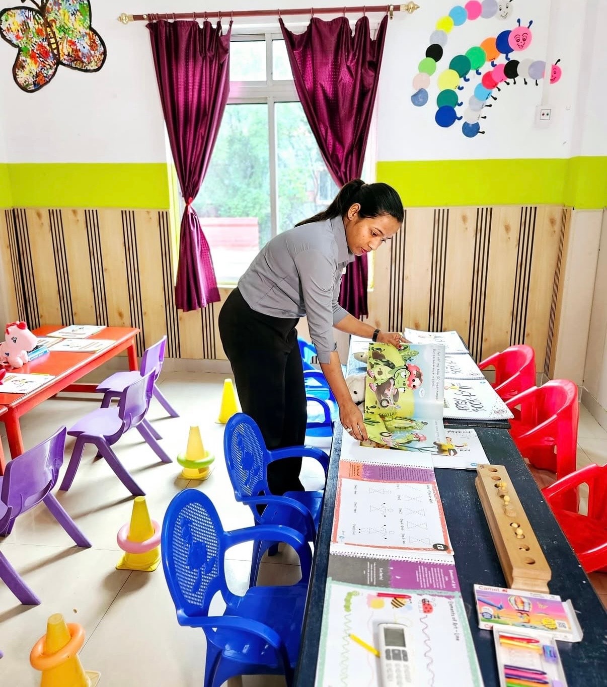 Teacher preparing activity materials in a Kidzee Bhetapara classroom