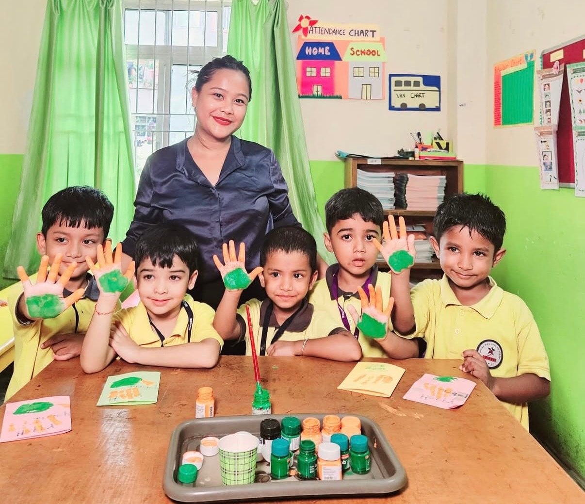 Children showing painted hands during an art activity at Kidzee Bhetapara