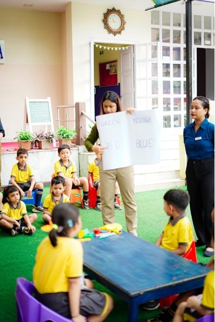 Teacher conducting an outdoor colour learning session at Kidzee Bhetapara